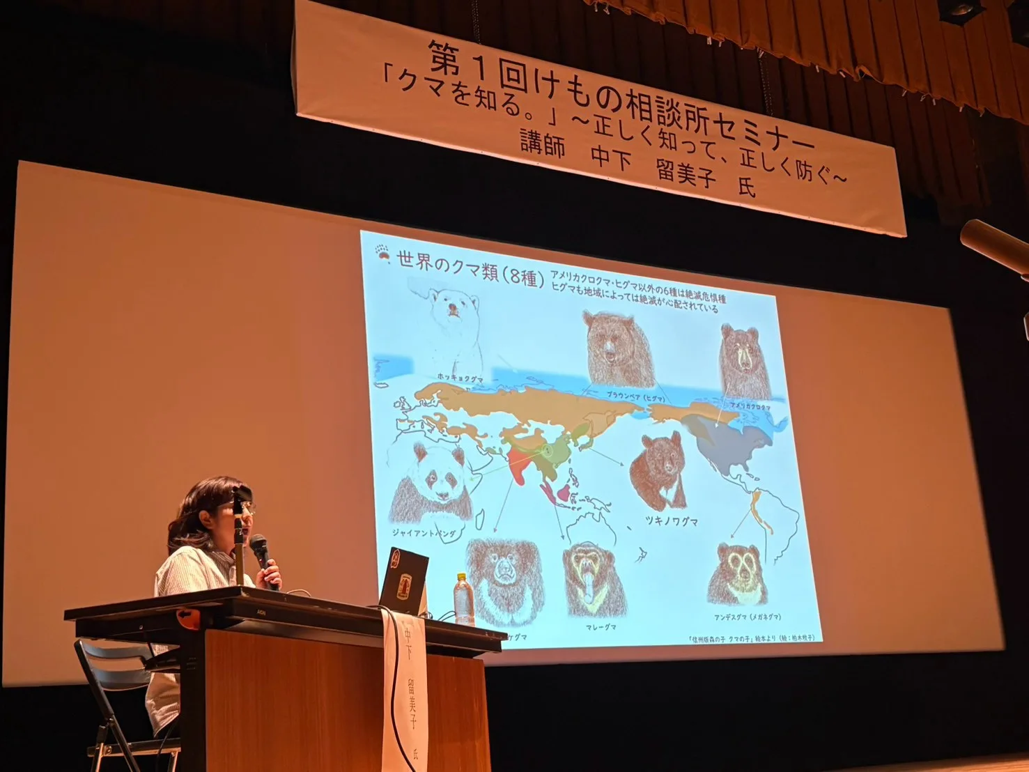 クマの生態についてスライドを使って解説する講演の様子